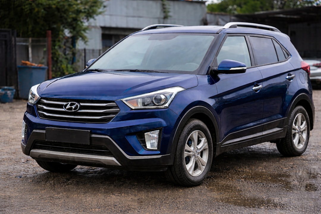 A blue hyundai suv parked on a wet street
